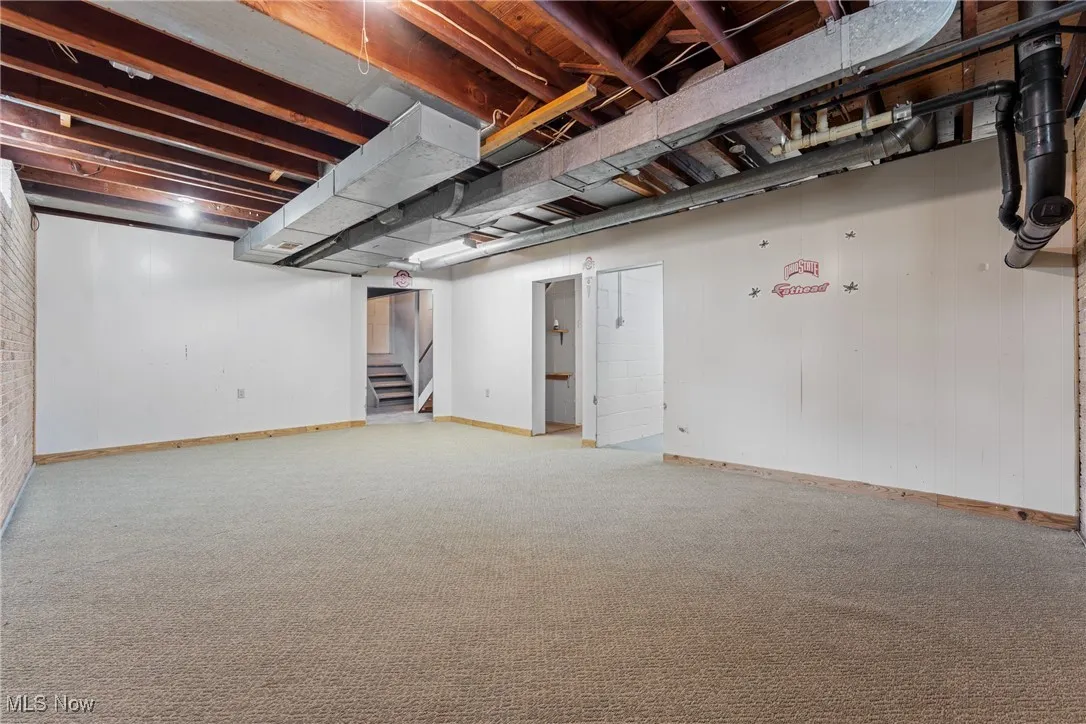 Finished below grade area featuring light carpet and stairs