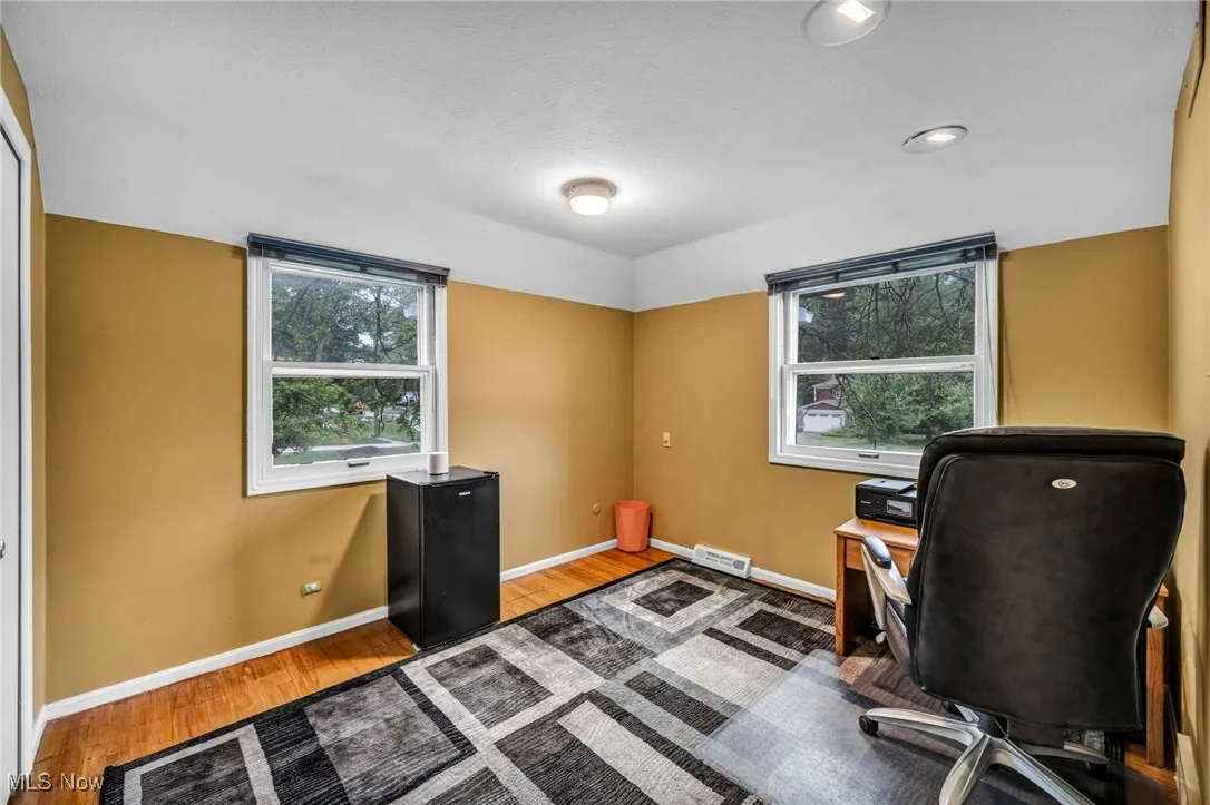 Home office with wood finished floors, plenty of natural light, and a textured ceiling