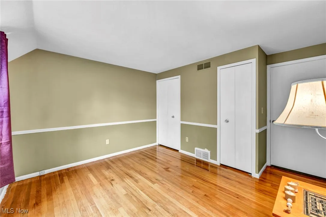 Unfurnished bedroom featuring light wood-type flooring and multiple closets