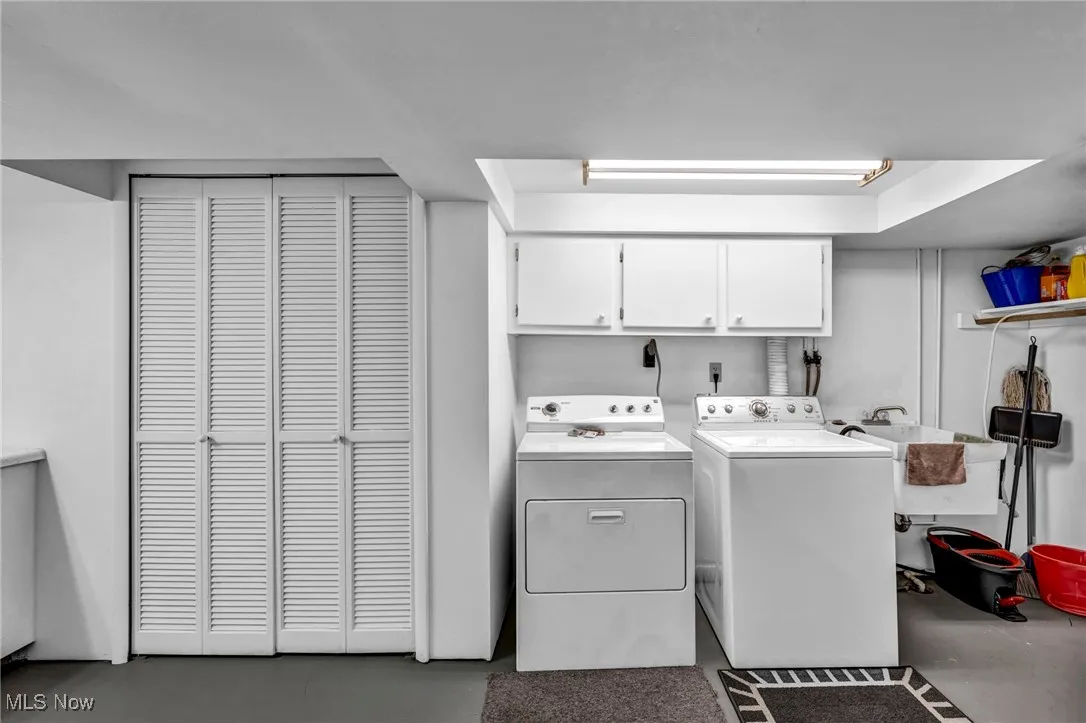 Washroom with washing machine and clothes dryer and cabinet space
