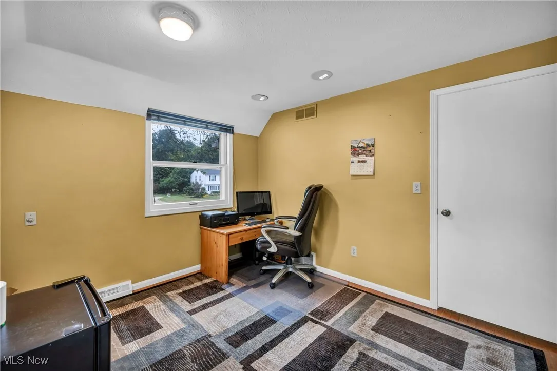 Office with baseboards and vaulted ceiling