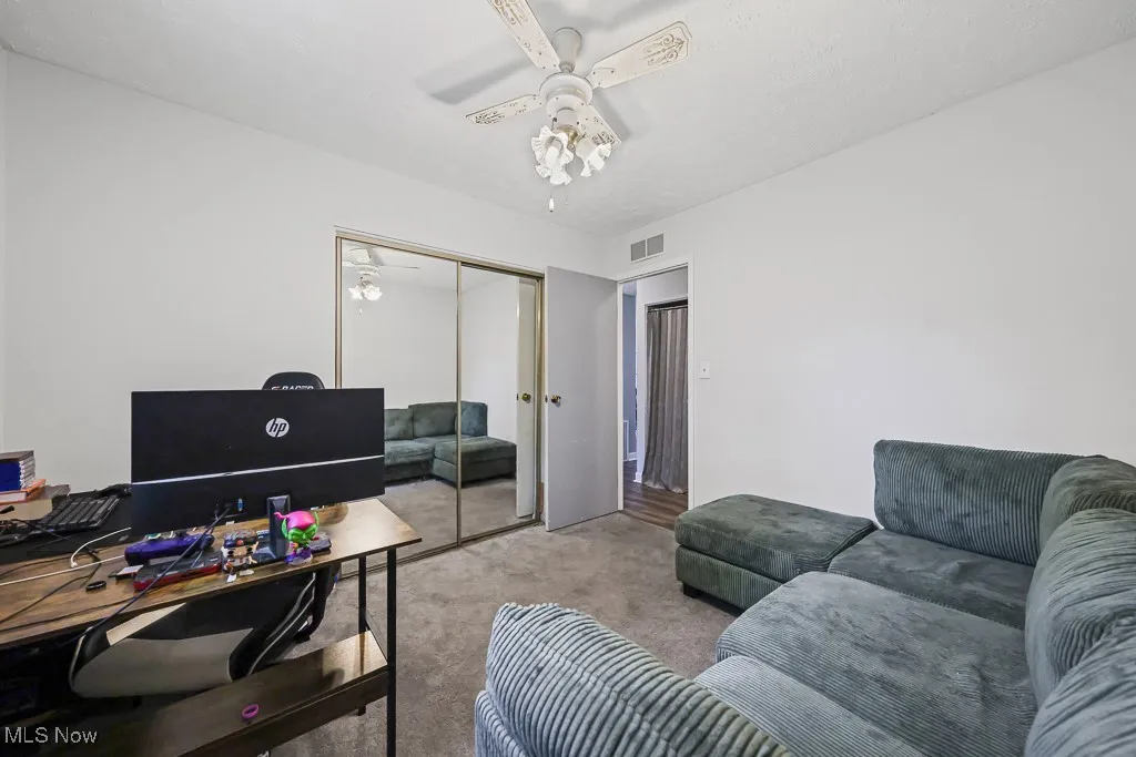 Carpeted bedroom with ceiling fan