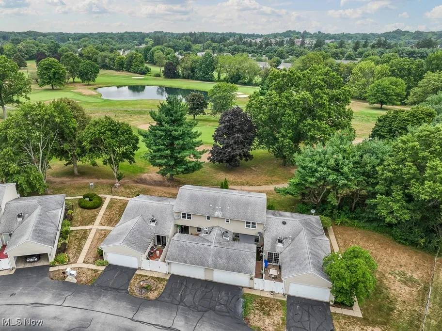 Drone / aerial view of a nearby body of water and a golf course