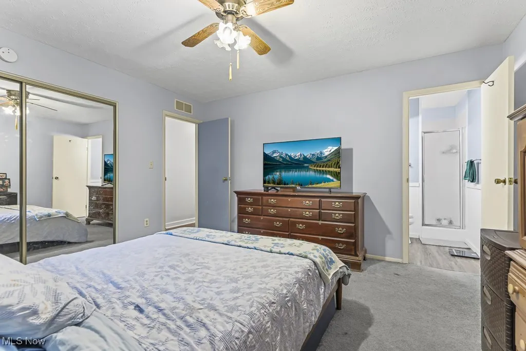 Bedroom featuring a ceiling fan, carpet floors, a textured ceiling, and a closet