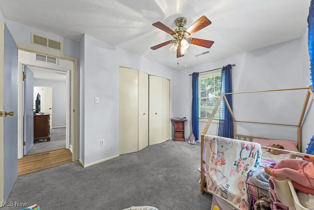 Bedroom featuring carpet flooring, ceiling fan, and a closet