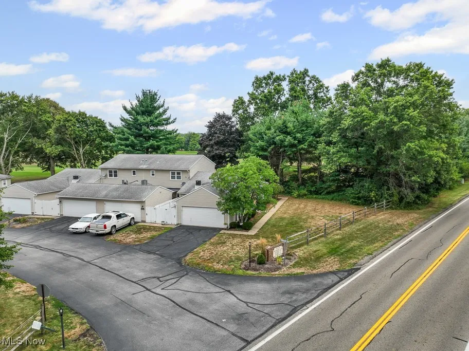 Aerial view of property and surrounding area featuring a tree filled landscape