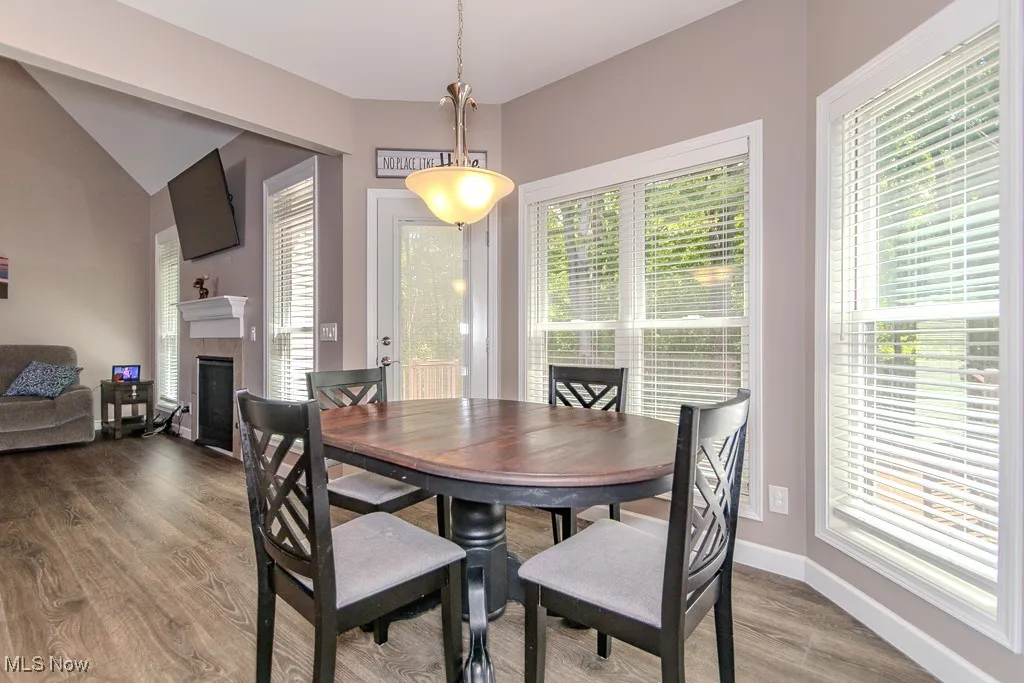 Dining area featuring wood finished floors and a fireplace