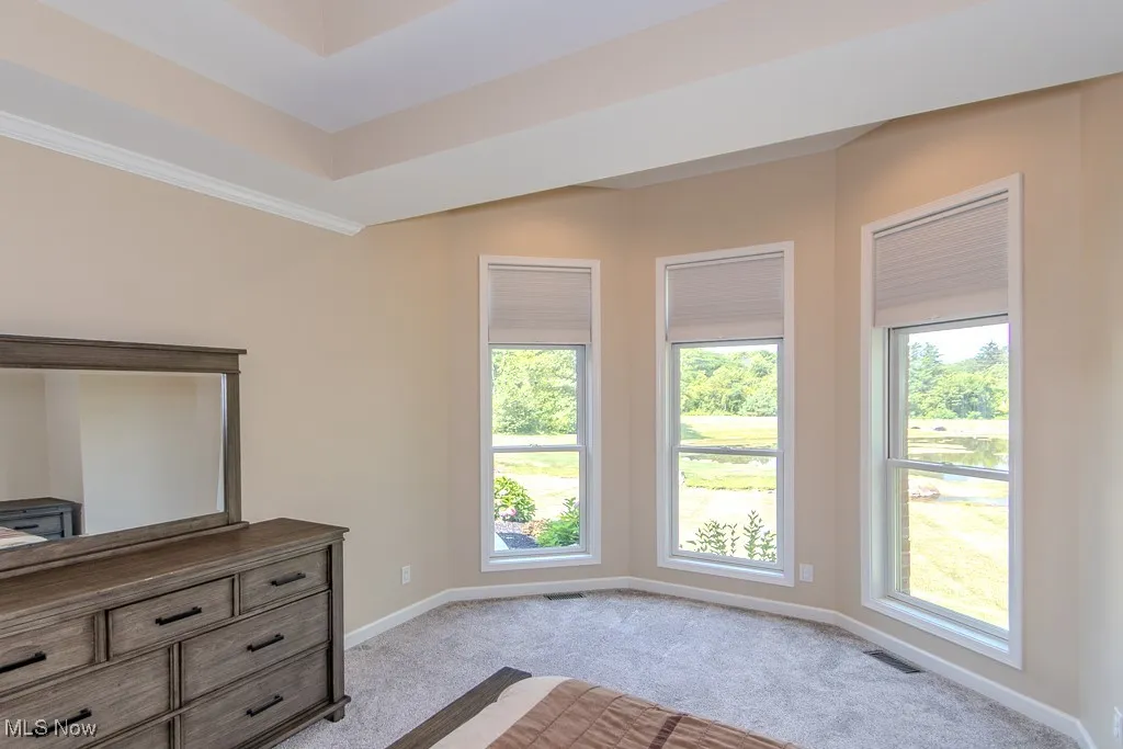 Unfurnished bedroom with light colored carpet and baseboards