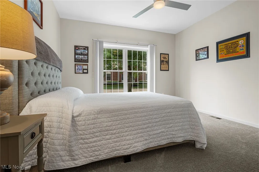 Carpeted bedroom with baseboards and a ceiling fan