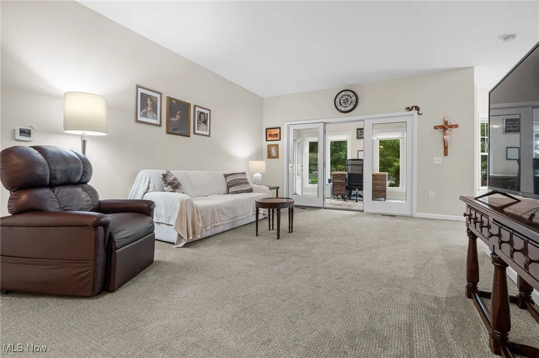Living room with light colored carpet and baseboards