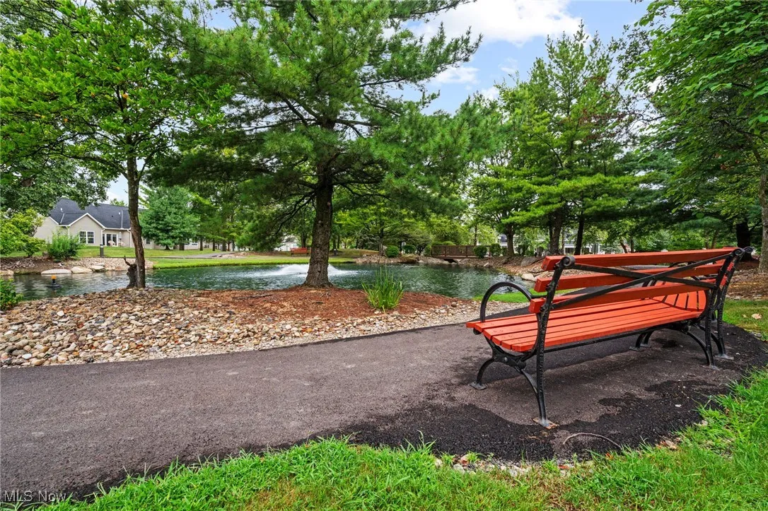 Surrounding community featuring a water view and view of wooded area