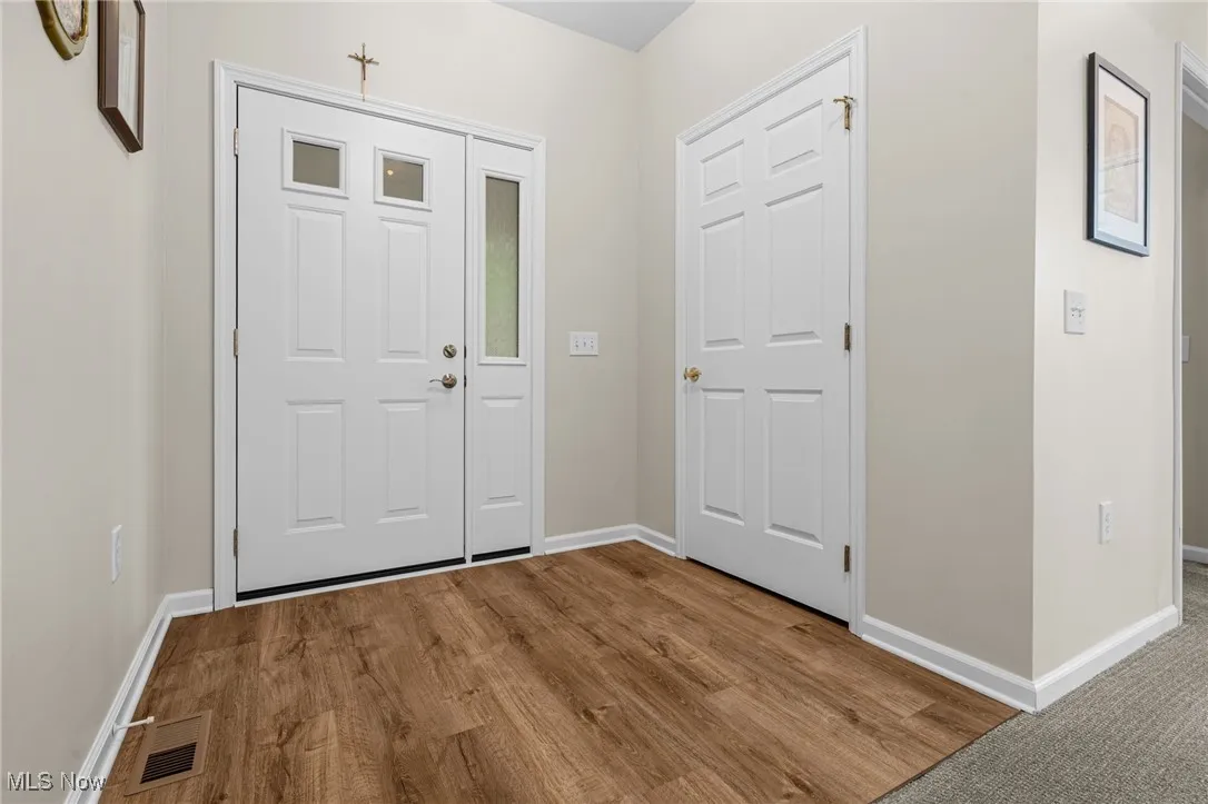 Entryway with baseboards and wood finished floors