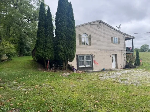 Back of property with a lawn
