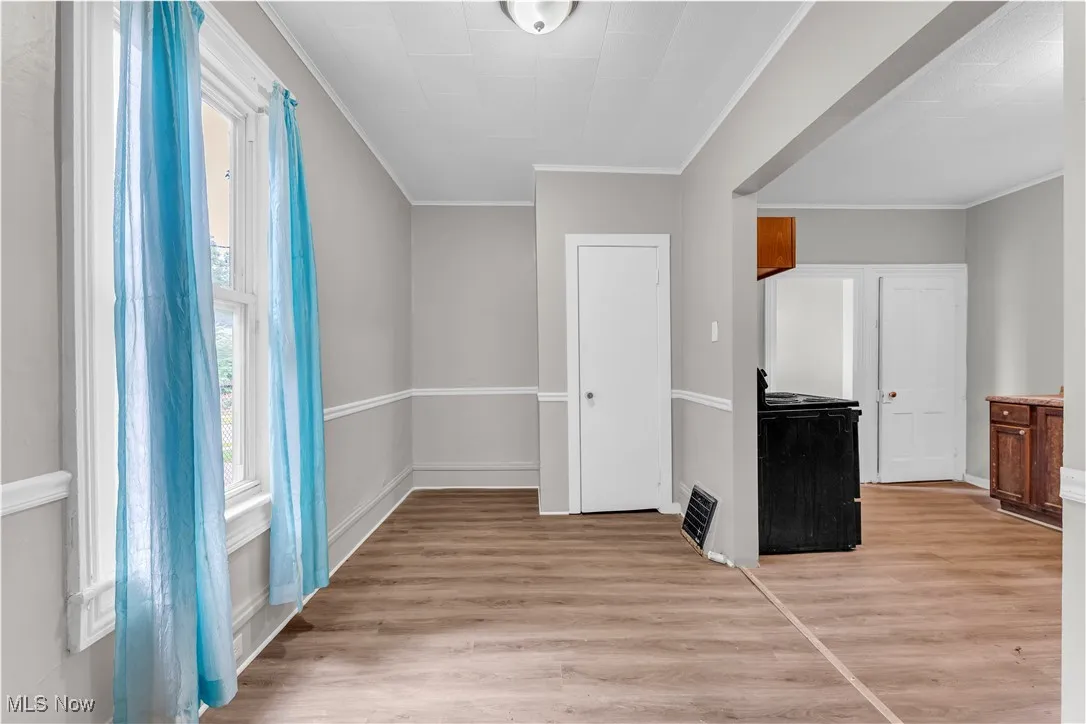 Foyer entrance with light wood finished floors and ornamental molding
