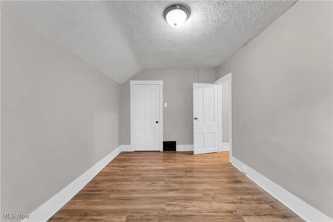Additional living space featuring wood finished floors and a textured ceiling