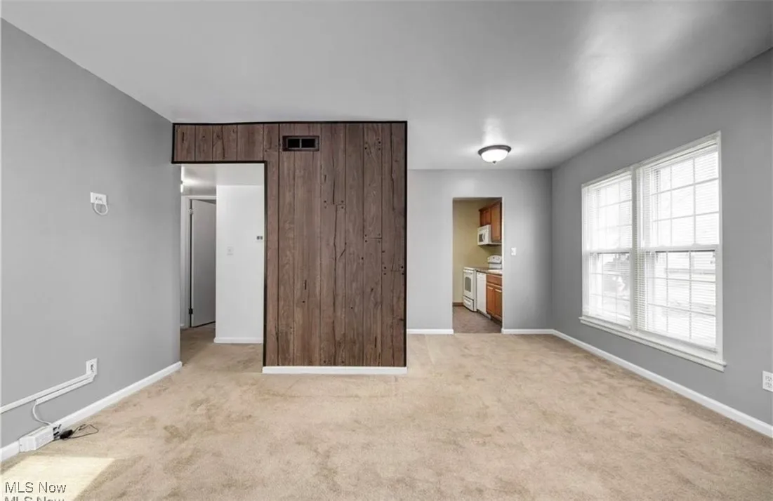 Unfurnished bedroom featuring light colored carpet and ensuite bath