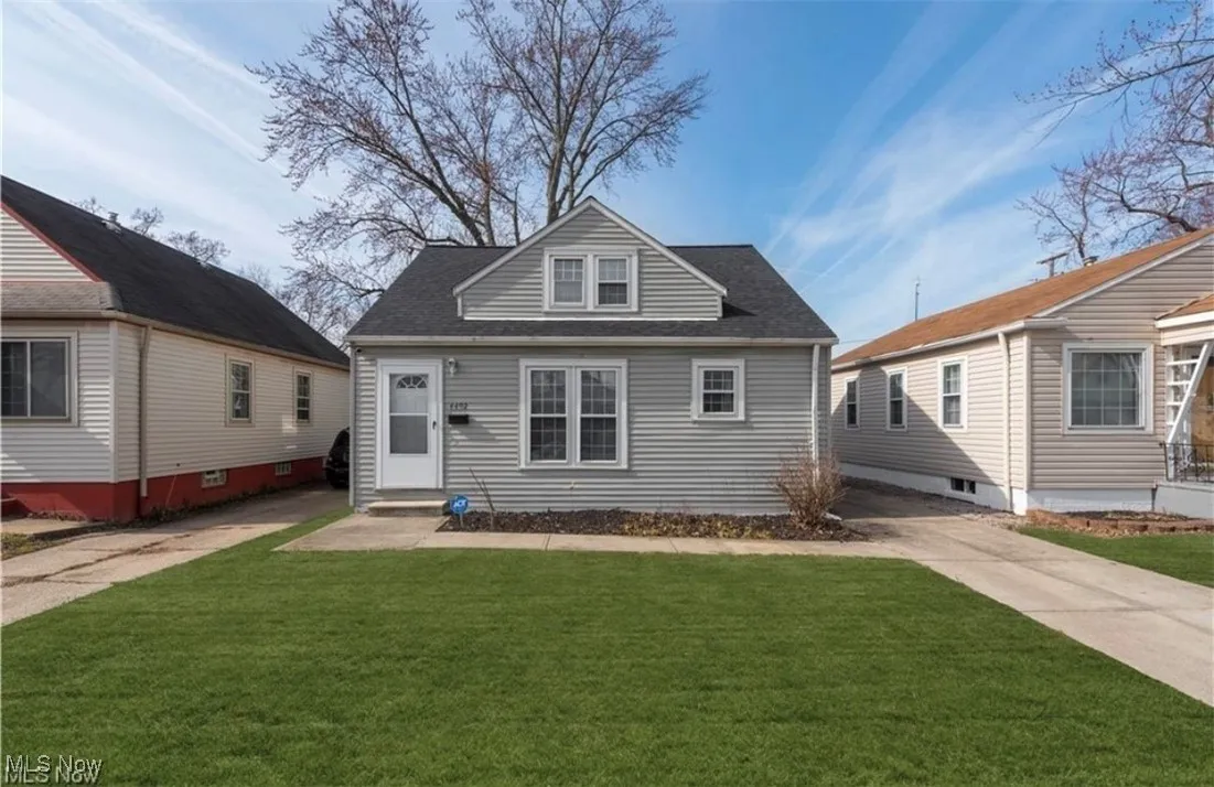 View of front of home featuring a front lawn, roof with shingles, and concrete driveway