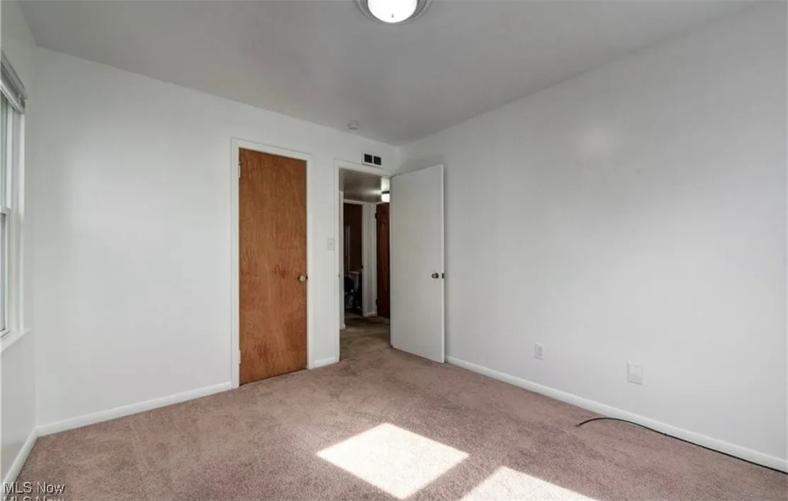 Unfurnished bedroom featuring carpet floors and baseboards