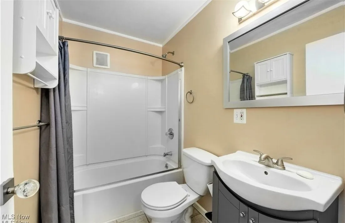 Bathroom featuring shower / tub combo, vanity, and crown molding