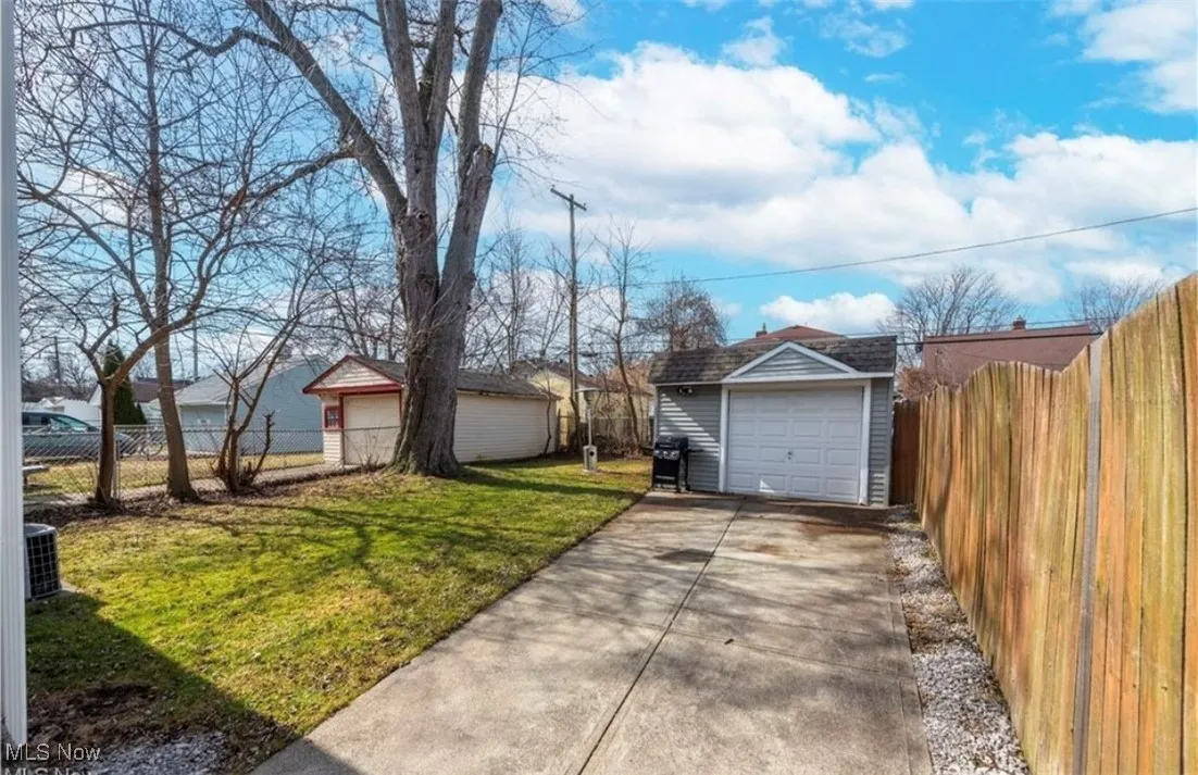 View of yard featuring driveway, an outbuilding, and a garage