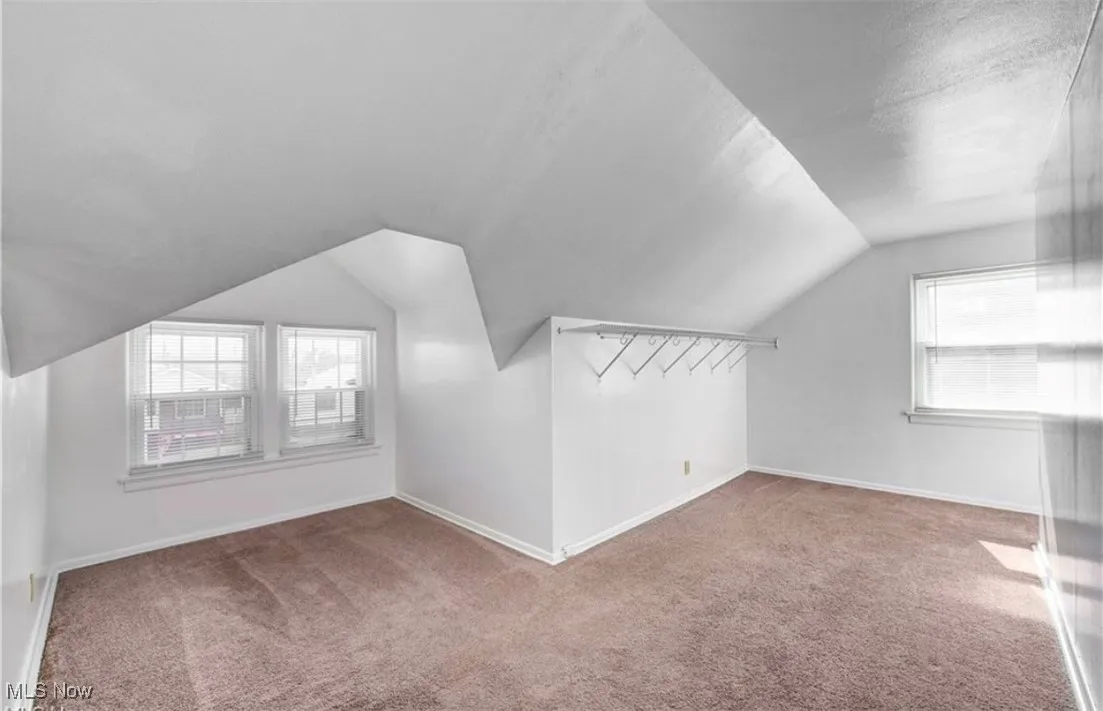 Additional living space with plenty of natural light, carpet, lofted ceiling, and a textured ceiling