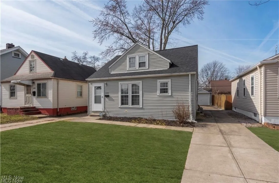 View of front facade featuring an outbuilding, a front yard, entry steps, concrete driveway, and roof with shingles