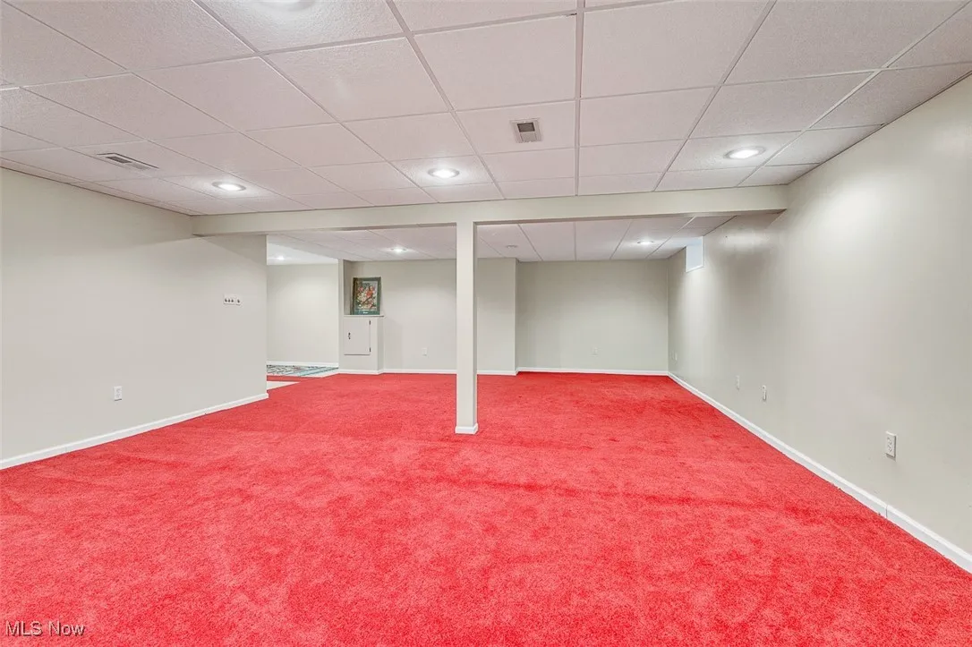 Finished basement featuring a drop ceiling, carpet, and recessed lighting