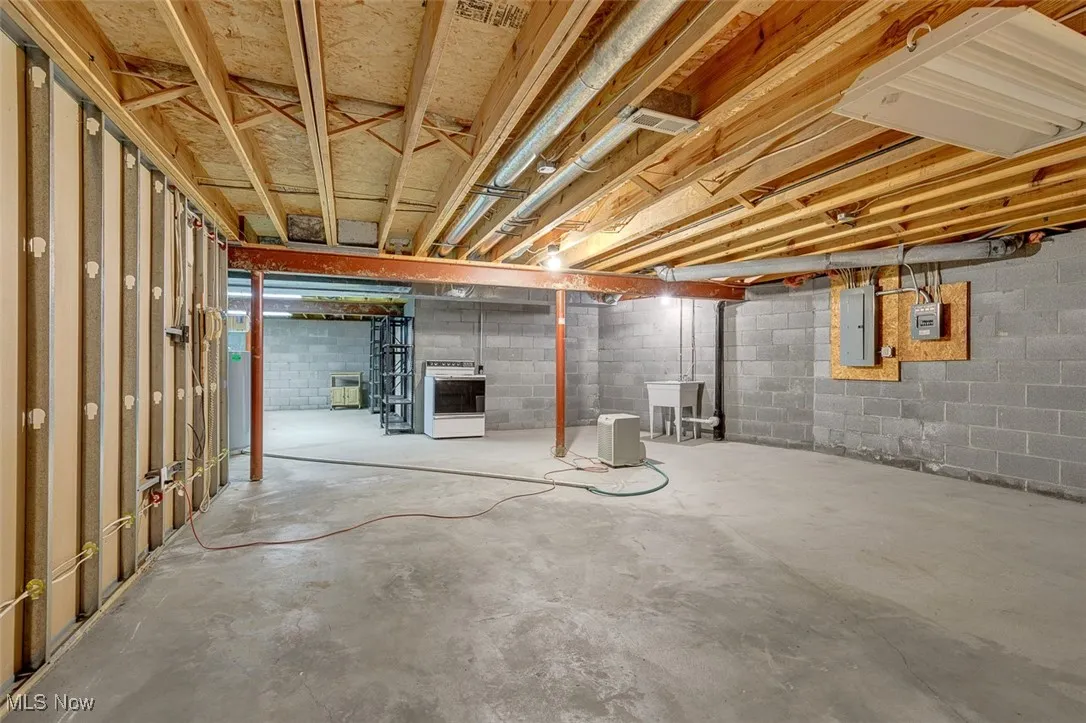 Unfinished basement with electric panel and heating unit