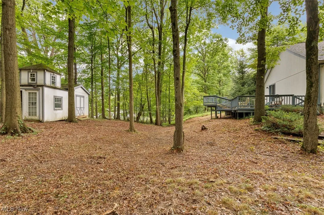 View of yard featuring an outbuilding and a wooden deck