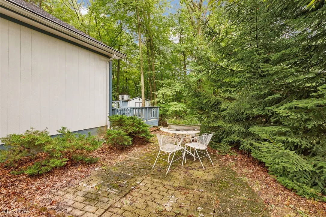 View of yard with a wooden deck and outdoor dining space