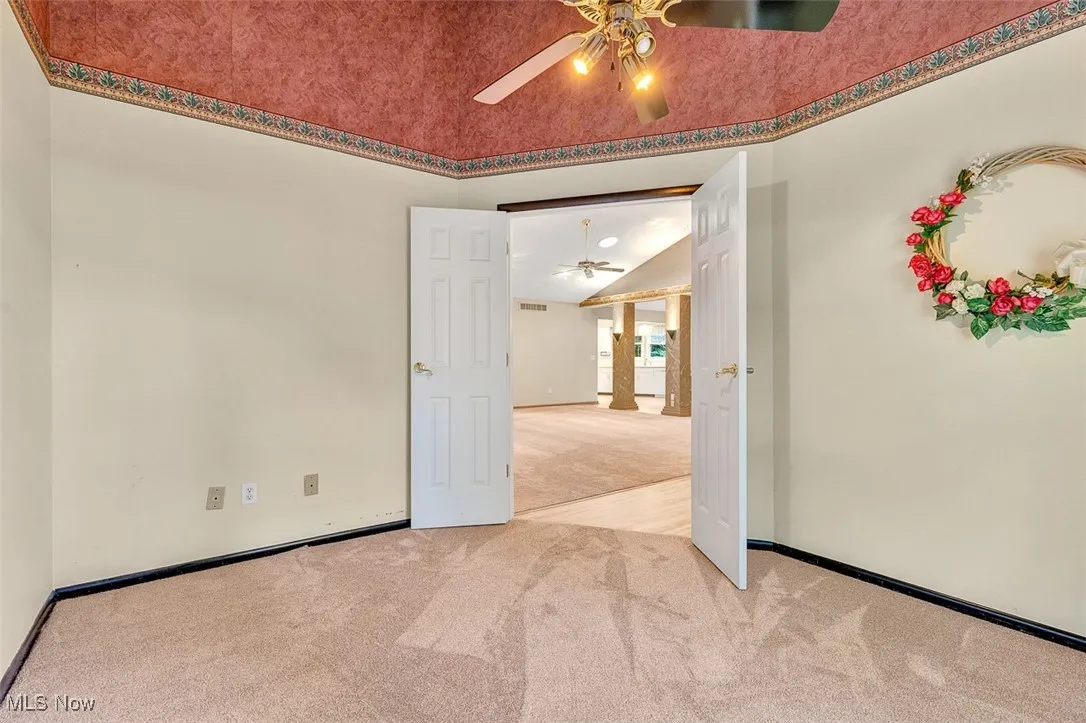 Empty room with light colored carpet and baseboards