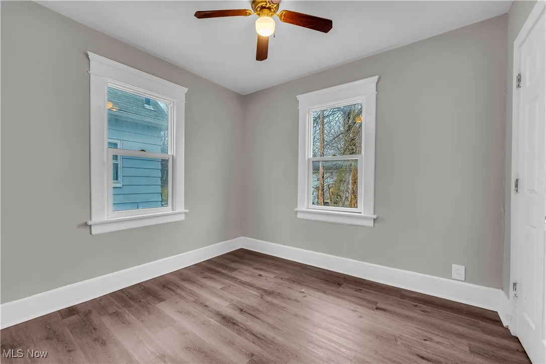 Spare room featuring baseboards and wood finished floors