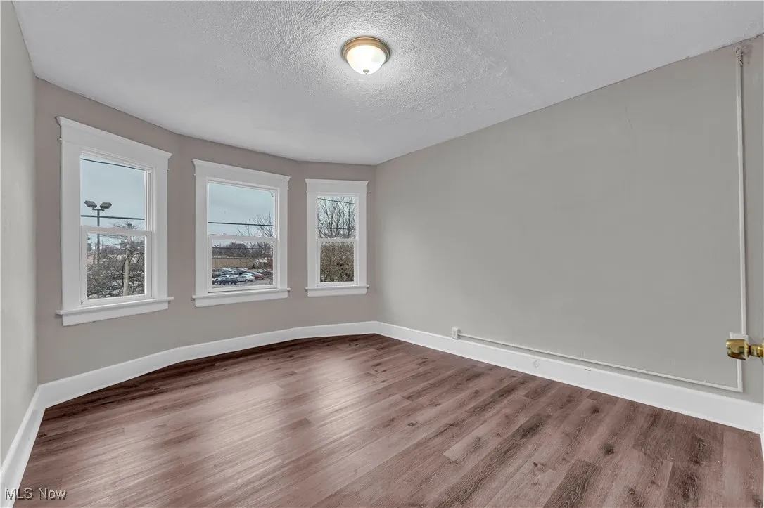Unfurnished room featuring a textured ceiling and wood finished floors