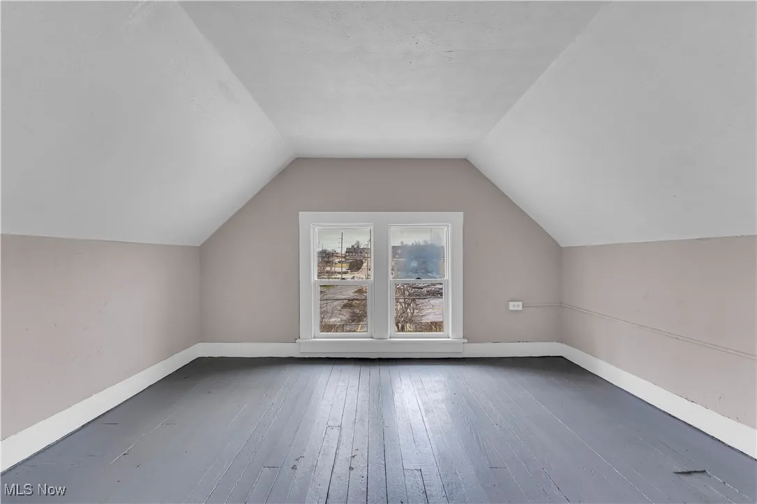 Additional living space featuring hardwood / wood-style flooring and lofted ceiling