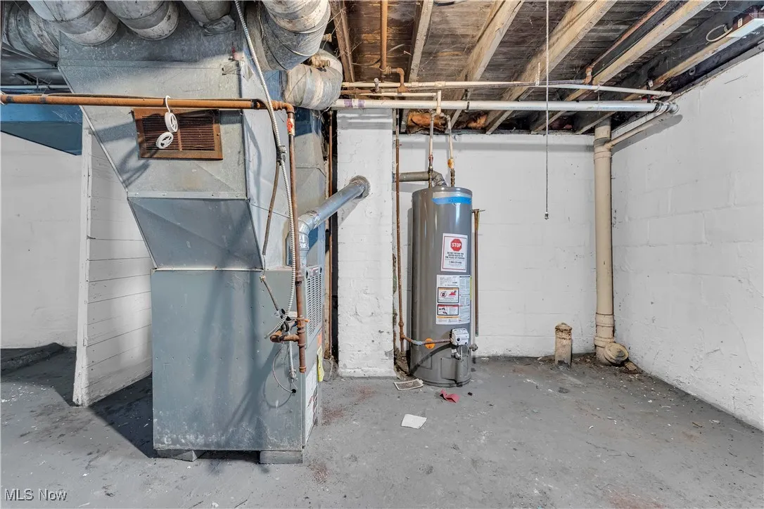 Utility room featuring water heater and heating unit