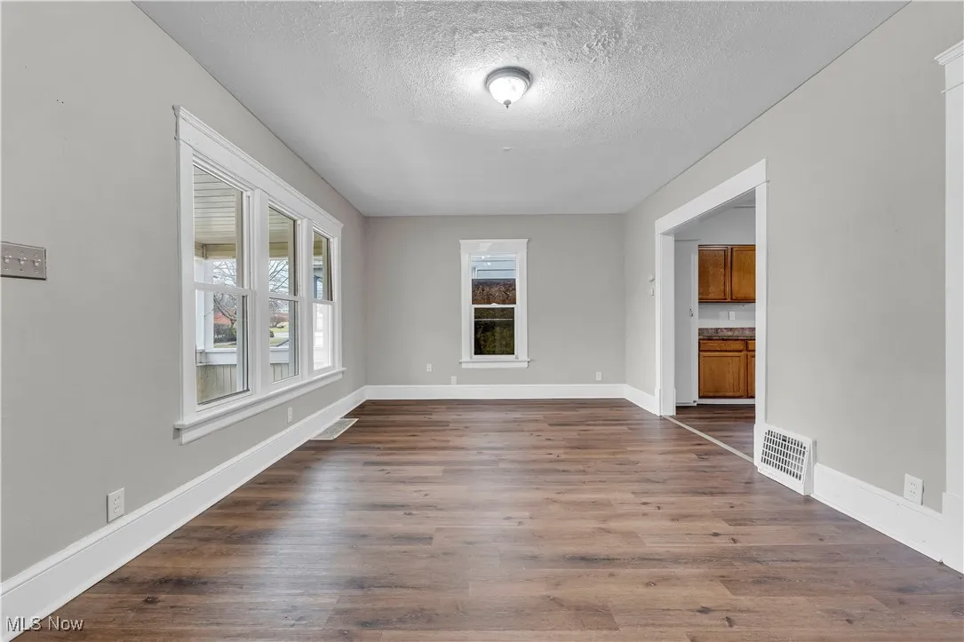 Empty room featuring a textured ceiling and dark wood finished floors
