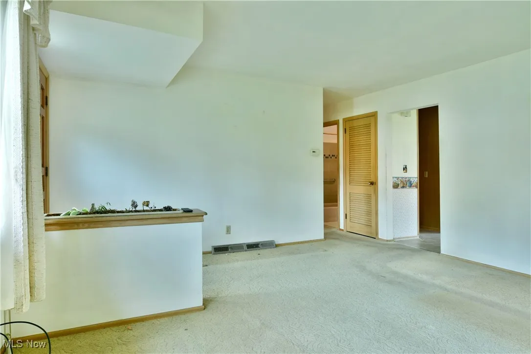 Spare room featuring carpet and baseboards