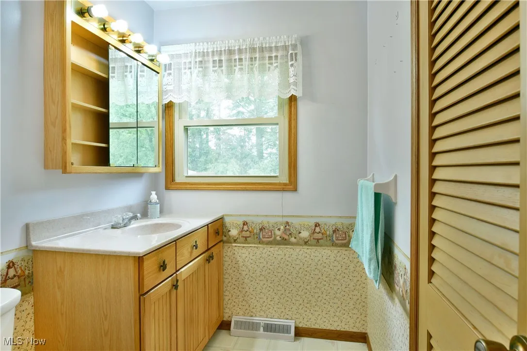 Bathroom with vanity and a wainscoted wall