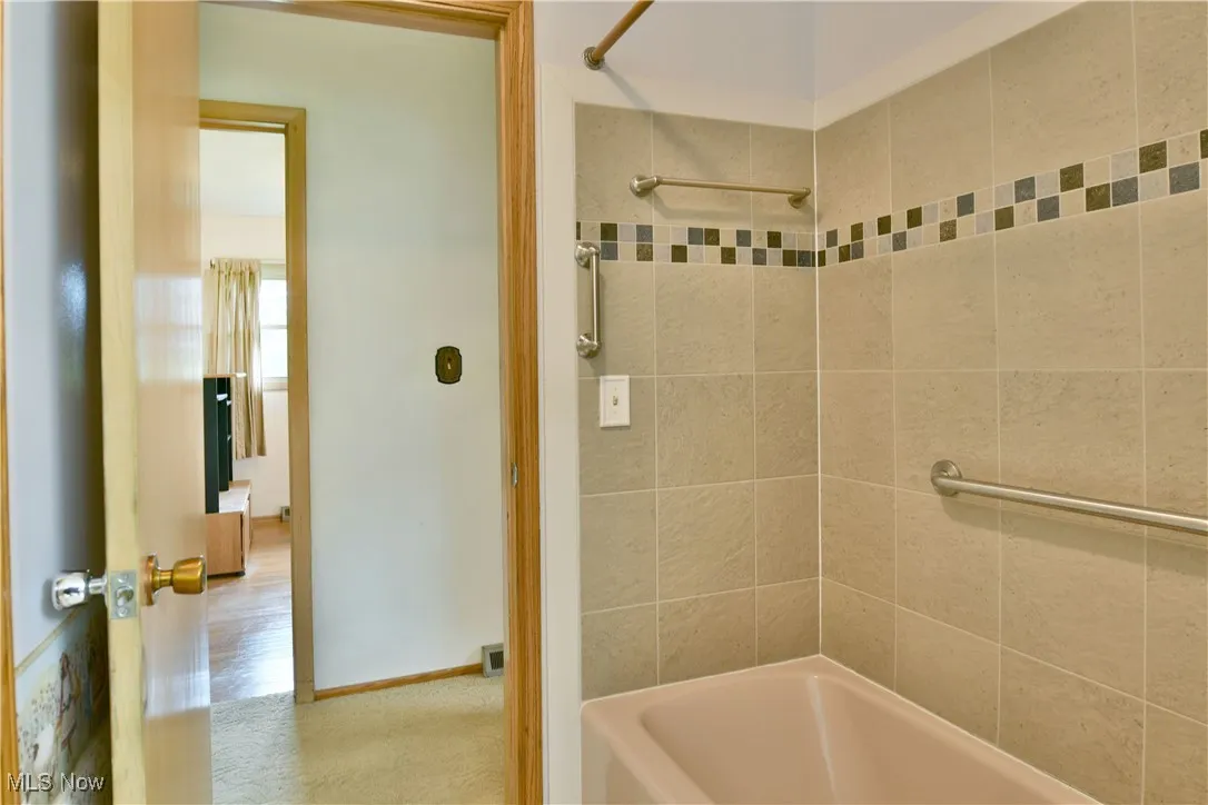 Bathroom featuring shower / washtub combination and baseboards