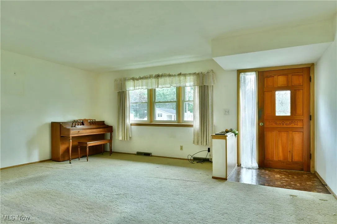 Foyer with carpet and baseboards