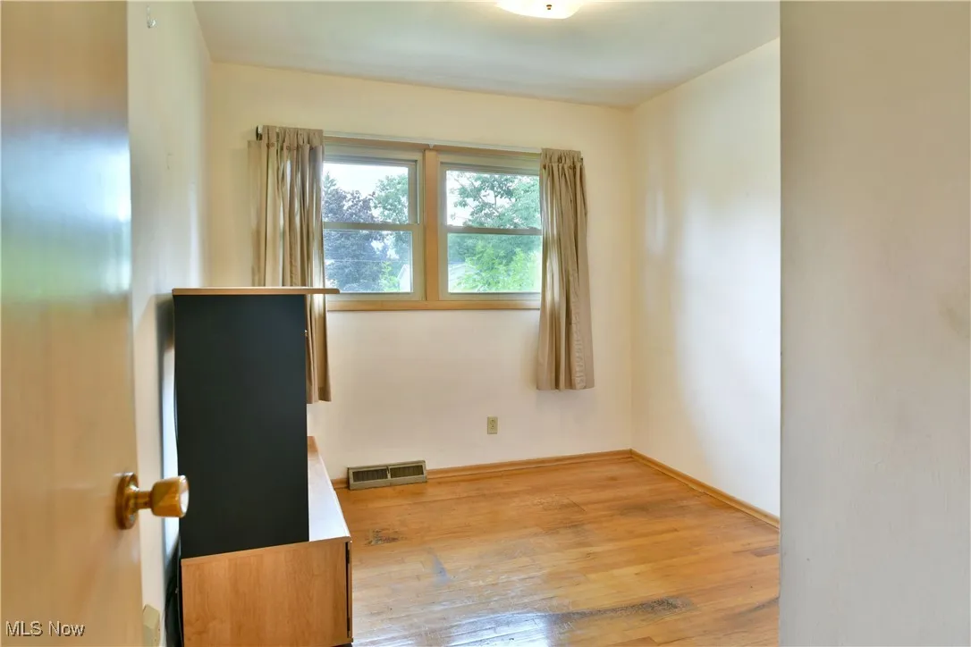 Empty room with light wood-type flooring and baseboards