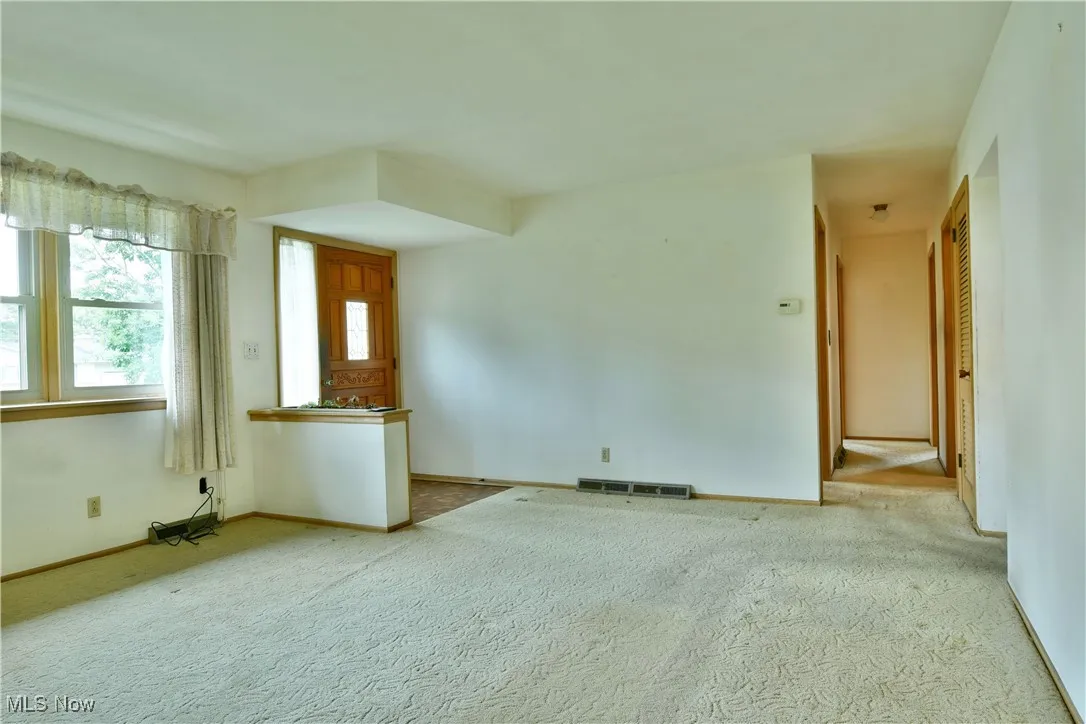 Unfurnished living room featuring carpet