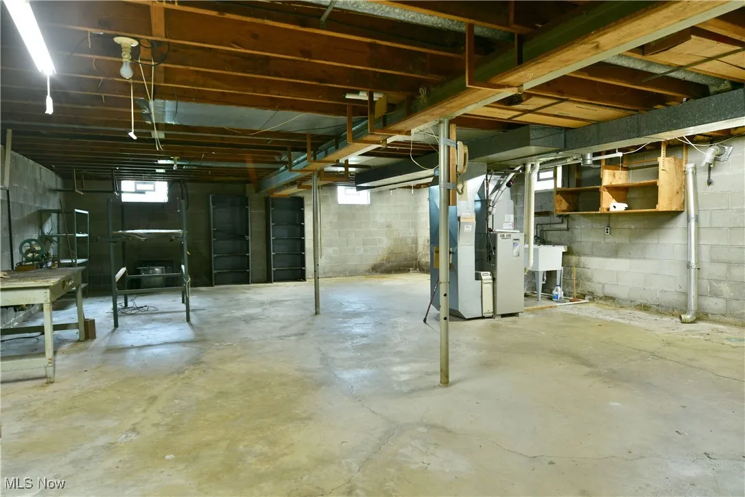 Below grade area with heating unit and a sink