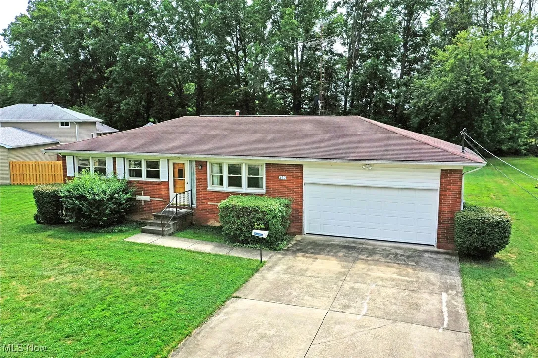 Single story home with a garage, driveway, and brick siding