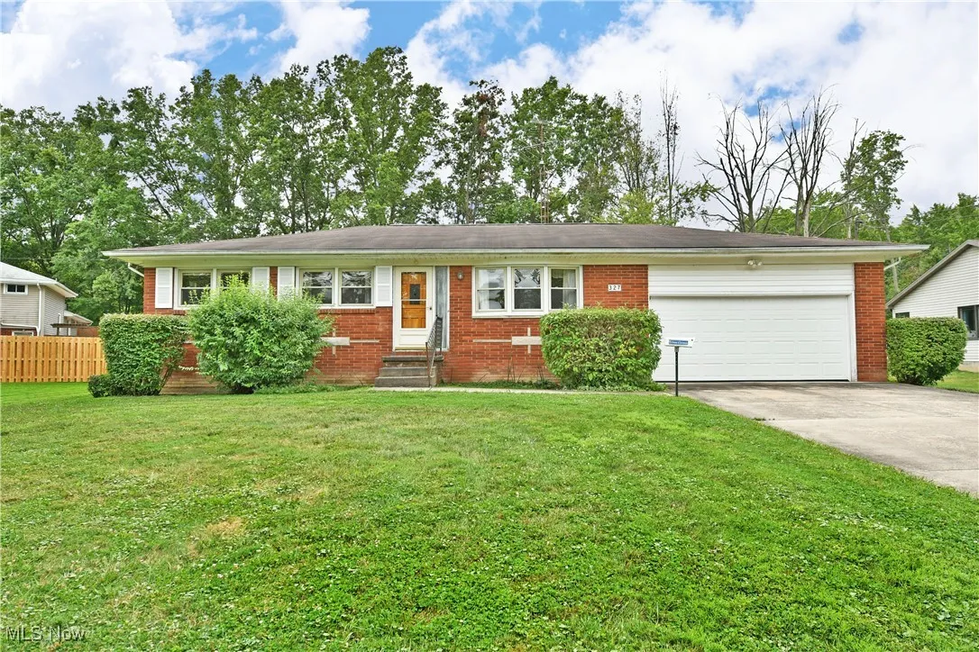 Single story home featuring driveway, a garage, brick siding, and entry steps