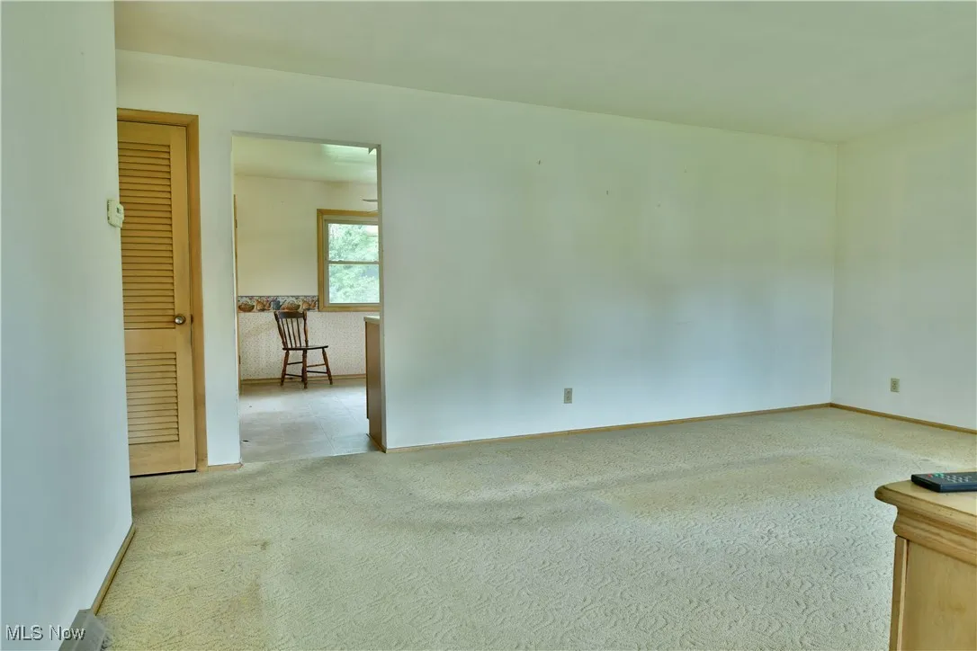 Empty room with light carpet and baseboards