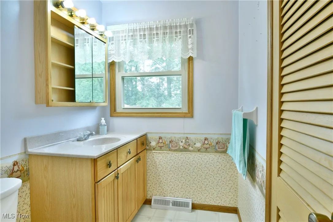 Half bathroom featuring vanity and a wainscoted wall