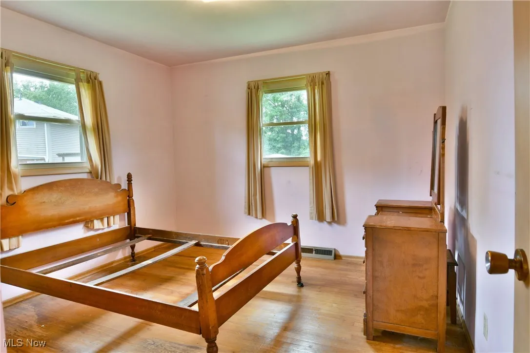 Bedroom with hardwood / wood-style flooring and baseboards