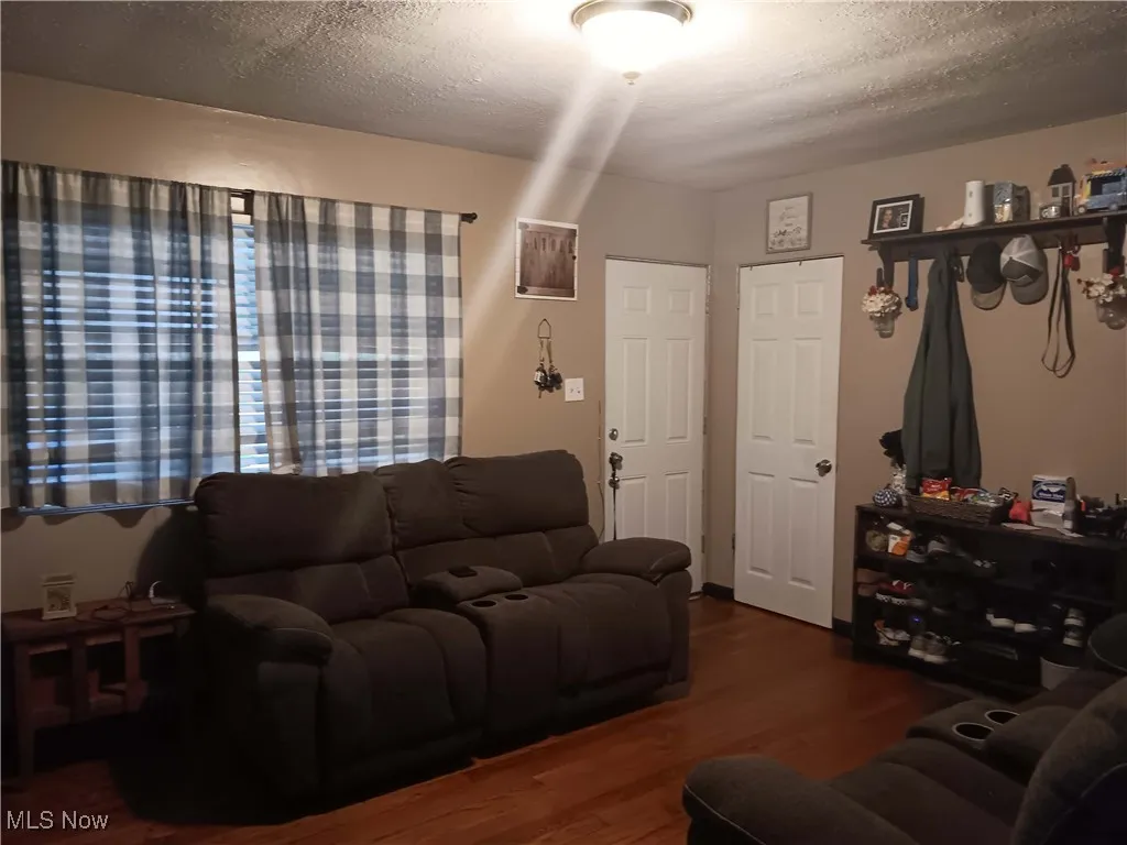 Living area featuring a textured ceiling and wood finished floors