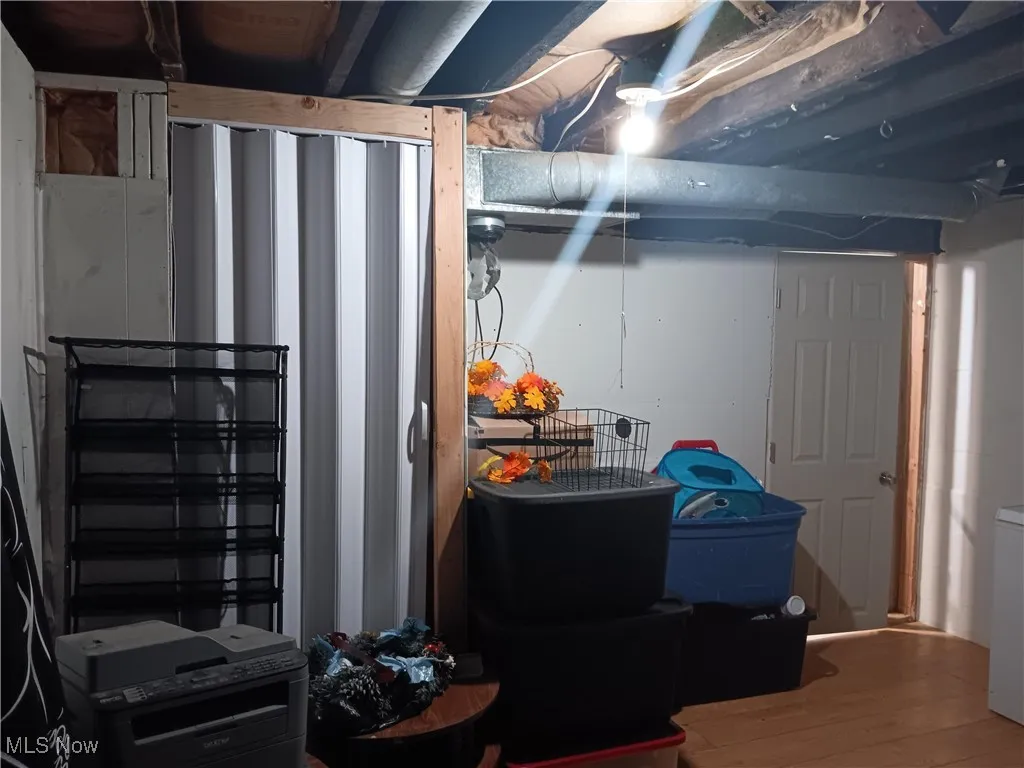 Unfinished basement with wood finished floors and washer / dryer